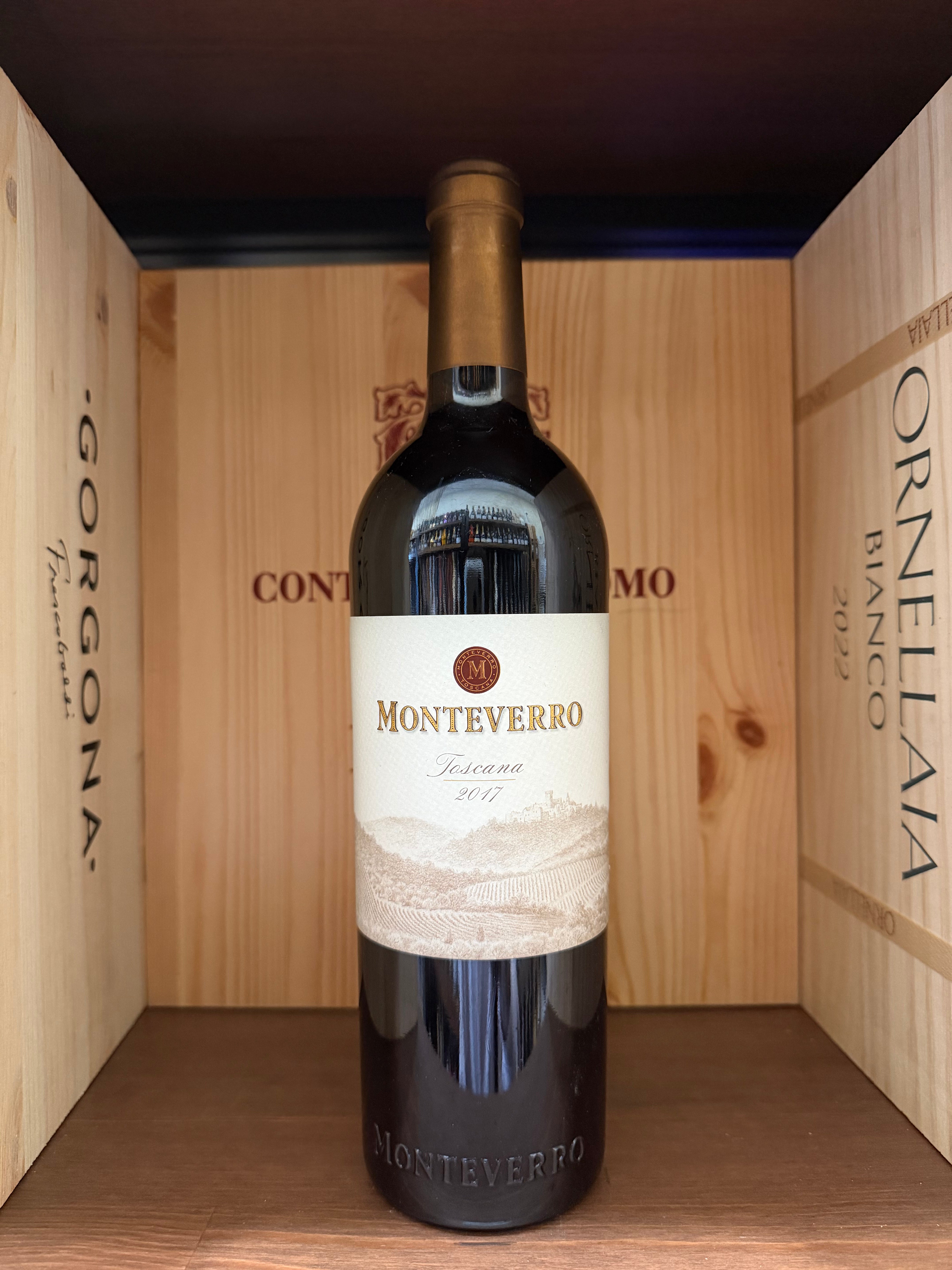 Bottiglia di vino Monteverro 2017 di Enoteche Toscane, etichetta elegante, sul tavolo con sfondo neutro.