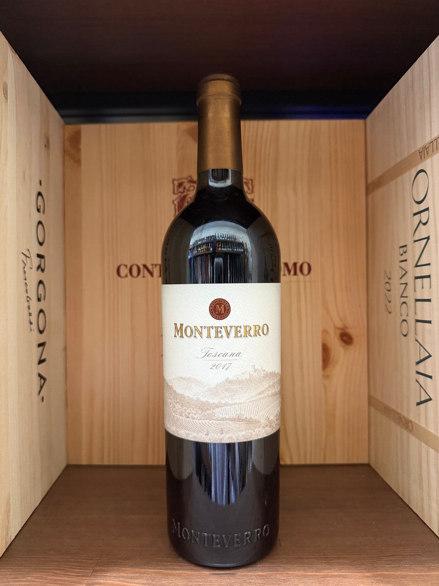 Bottiglia di vino Monteverro 2017 di Enoteche Toscane, etichetta elegante, sul tavolo con sfondo neutro.