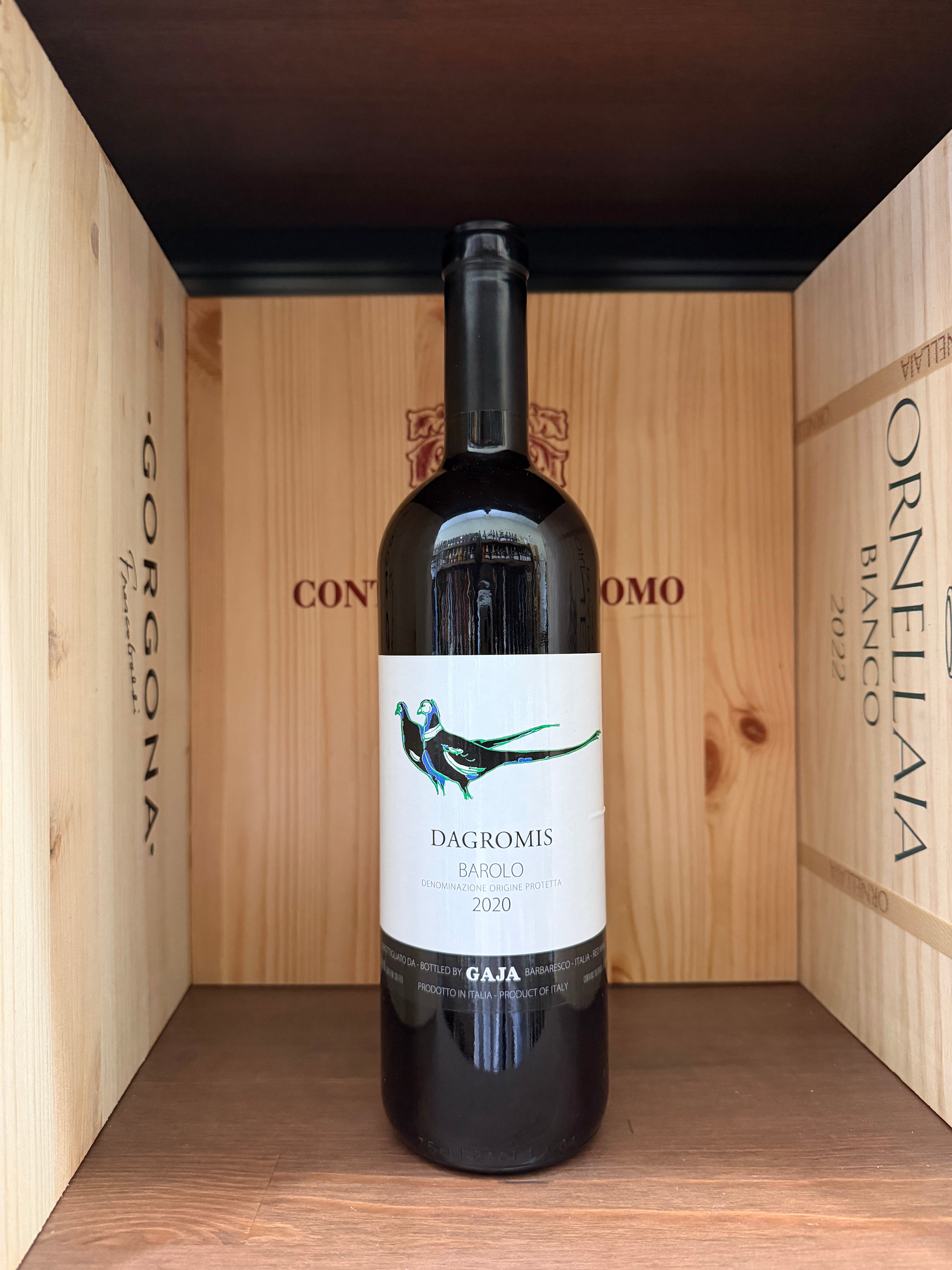 Bottiglia di vino Barolo Dagromis Gaja 2020 di Enoteche Toscane, etichetta elegante, in una cornice elegante con bicchieri di vino.