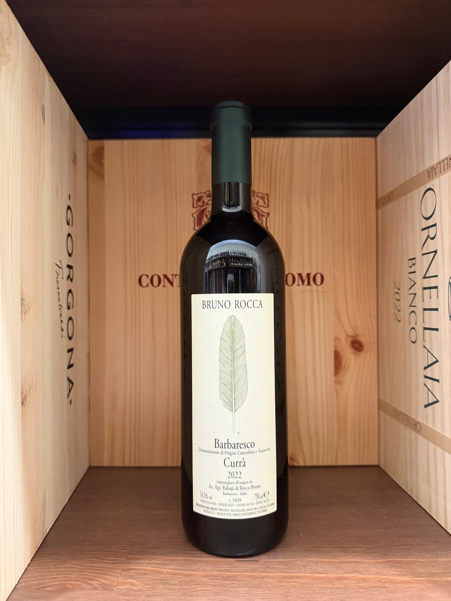 Bottiglia di vino Barbaresco Curra Bruno Rocca 2022, vista frontale con etichetta dettagliata, in un ambiente elegante.