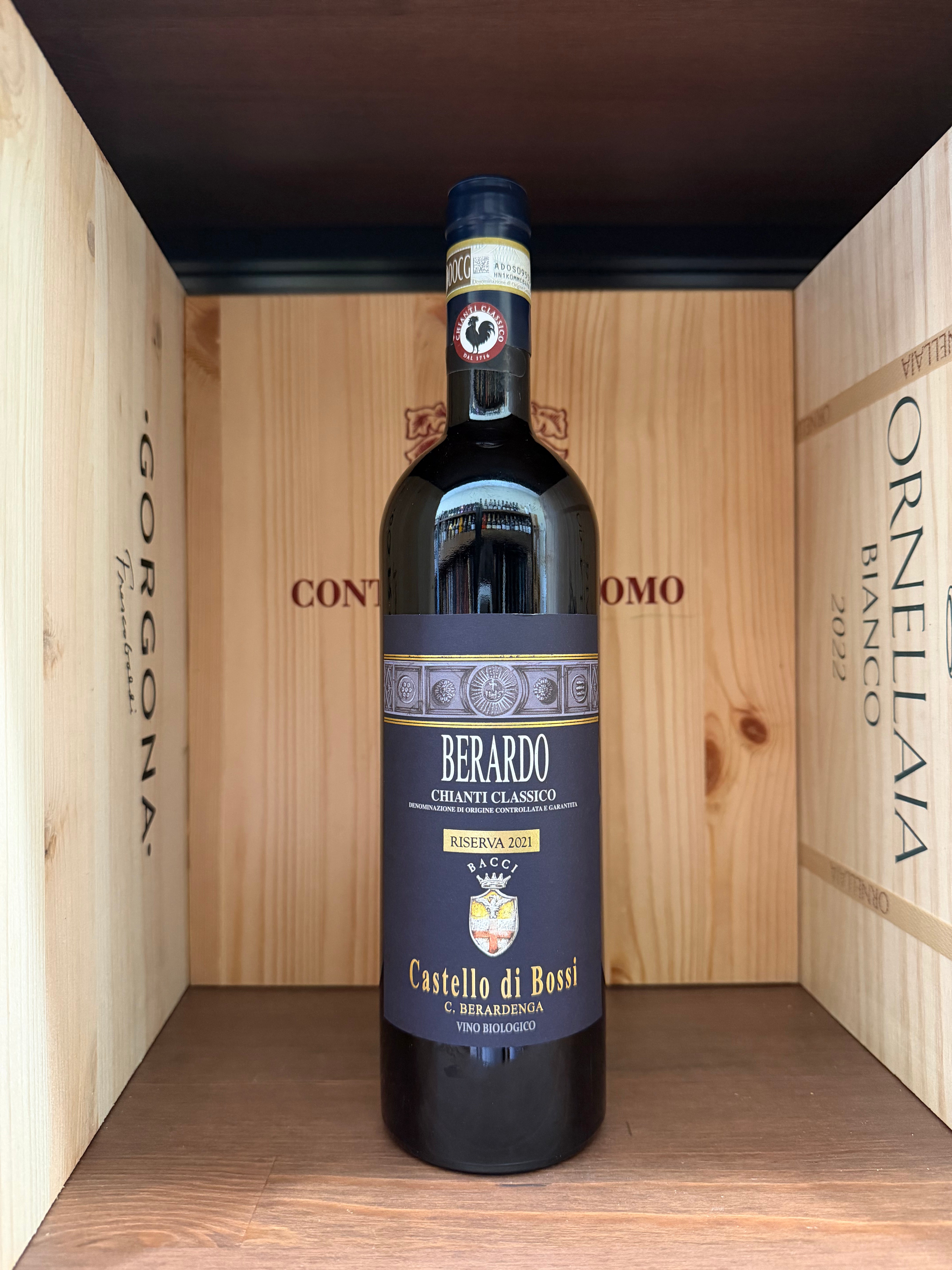 Bottiglia di vino Chianti Riserva Berardo Castello di Bossi 2021, etichetta elegante, in una scena con calici e sfondo rustico