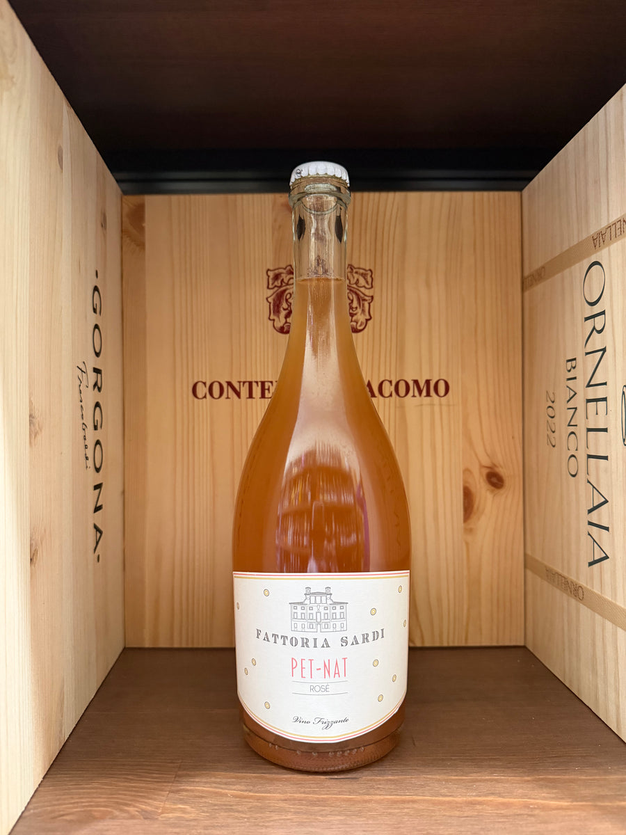 Vaso di vino Pet-Nat Fattoria Sardi 2023 prodotto da Enoteche Toscane, bottiglia con etichetta elegante e dettagli del vino.