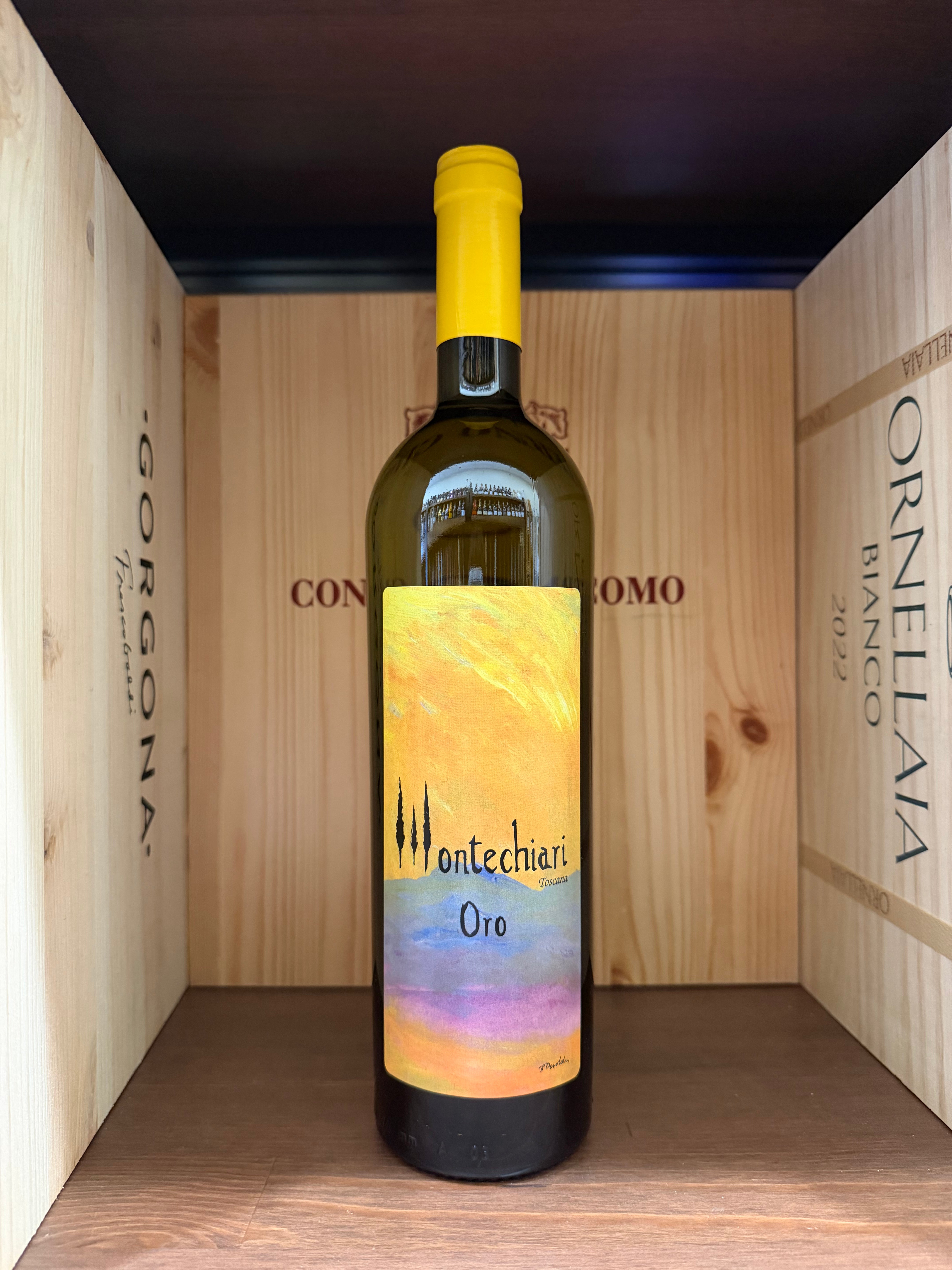 Bottiglia di Montechiari Oro 2022 di Enoteche Toscane, vino bianco in bottiglia con etichetta dorata, su sfondo neutro.