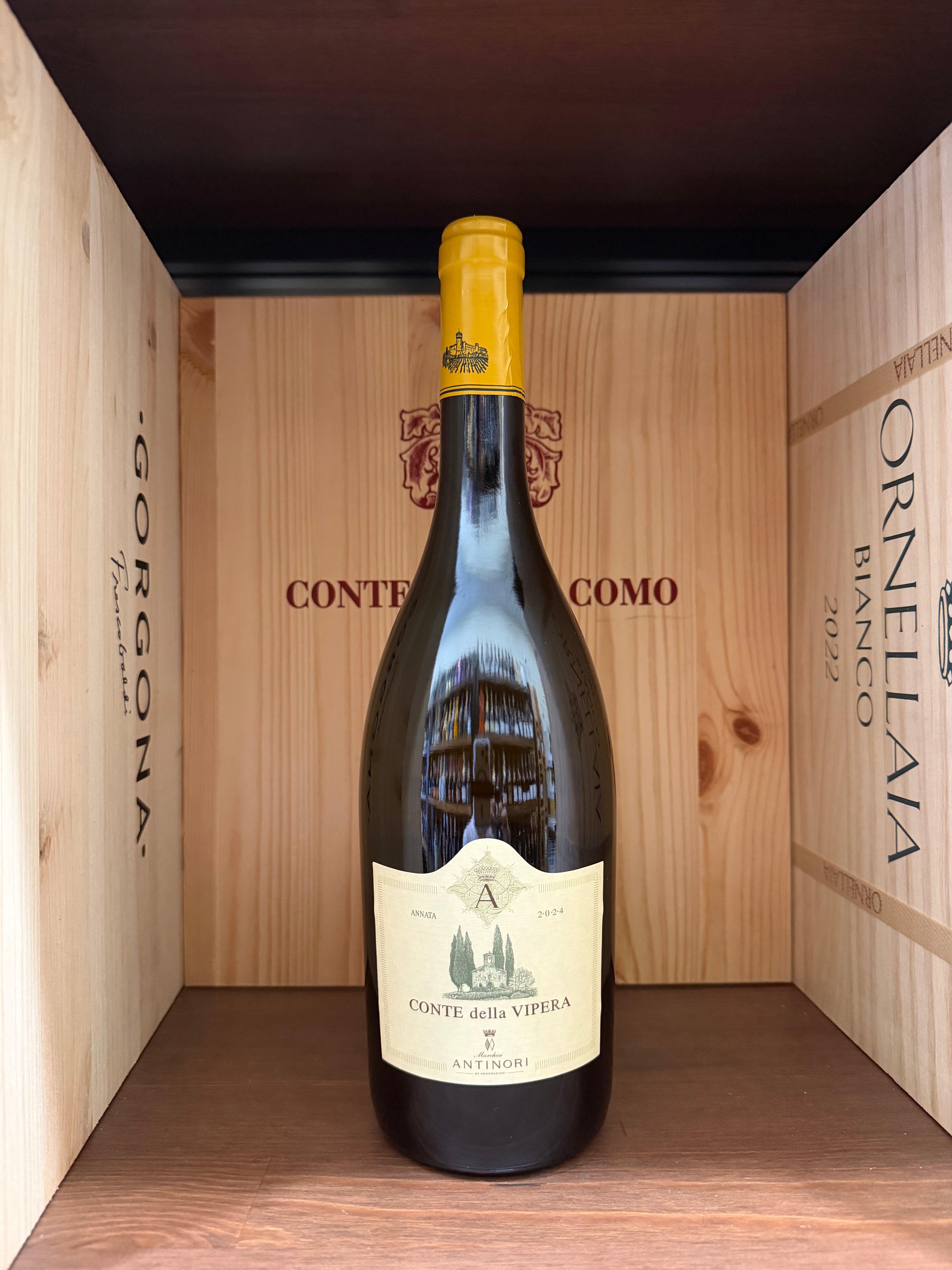 Bottiglia di vino Conte della Vipera 2024 Antinori, con etichetta elegante, posizionata su una superficie di legno, luce soffusa.