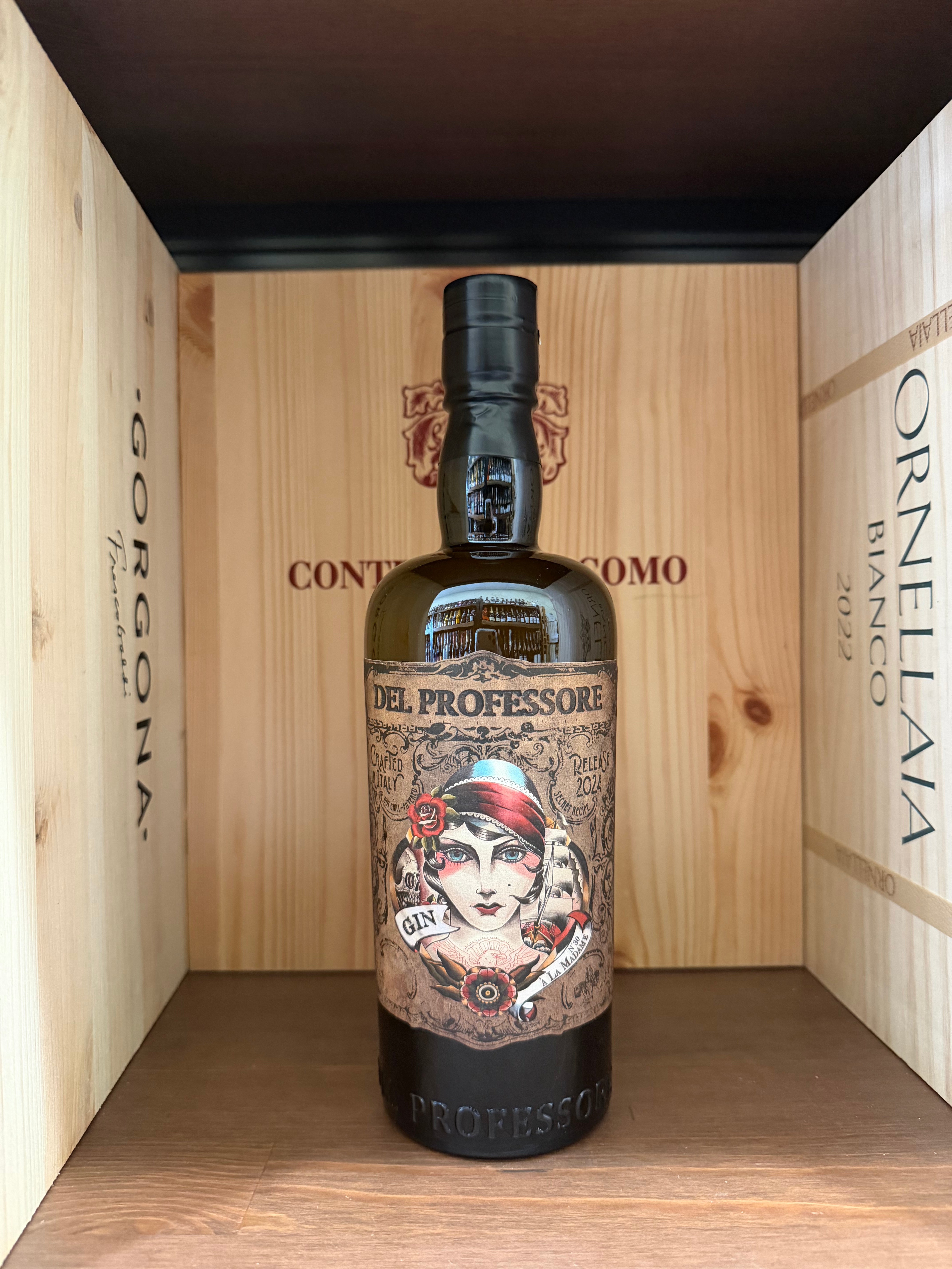 Bottiglia di Gin Del Professore Madame con etichetta elegante, in un calice di cristallo su sfondo neutro.