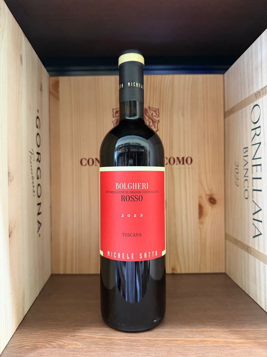 Bottiglia di vino Michele Satta Bolgheri 2023, etichetta elegante, in un calice di vino rosso, su sfondo neutro