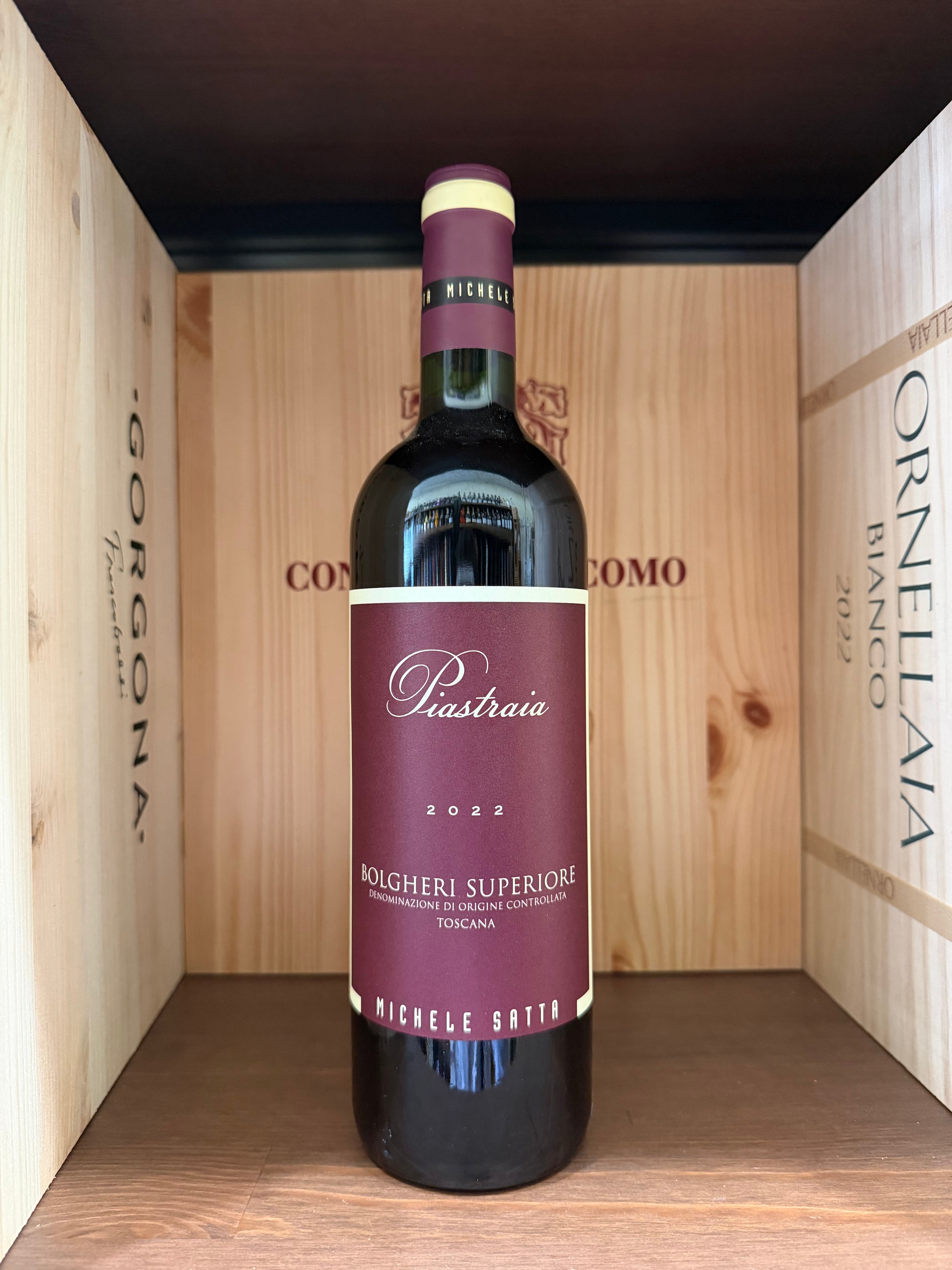 Piastraia Bolgheri Superiore 2022 di Michele Satta, bottiglia di vino rosso con etichetta elegante, posizionata su superficie chiara