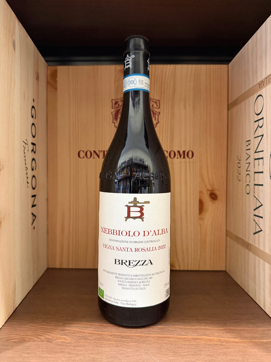 Bottiglia di Nebbiolo D'Alba Vigna Santa Rosalia 2022 di Brezza, vino rosso con etichetta dettagliata, in un calice di vino.