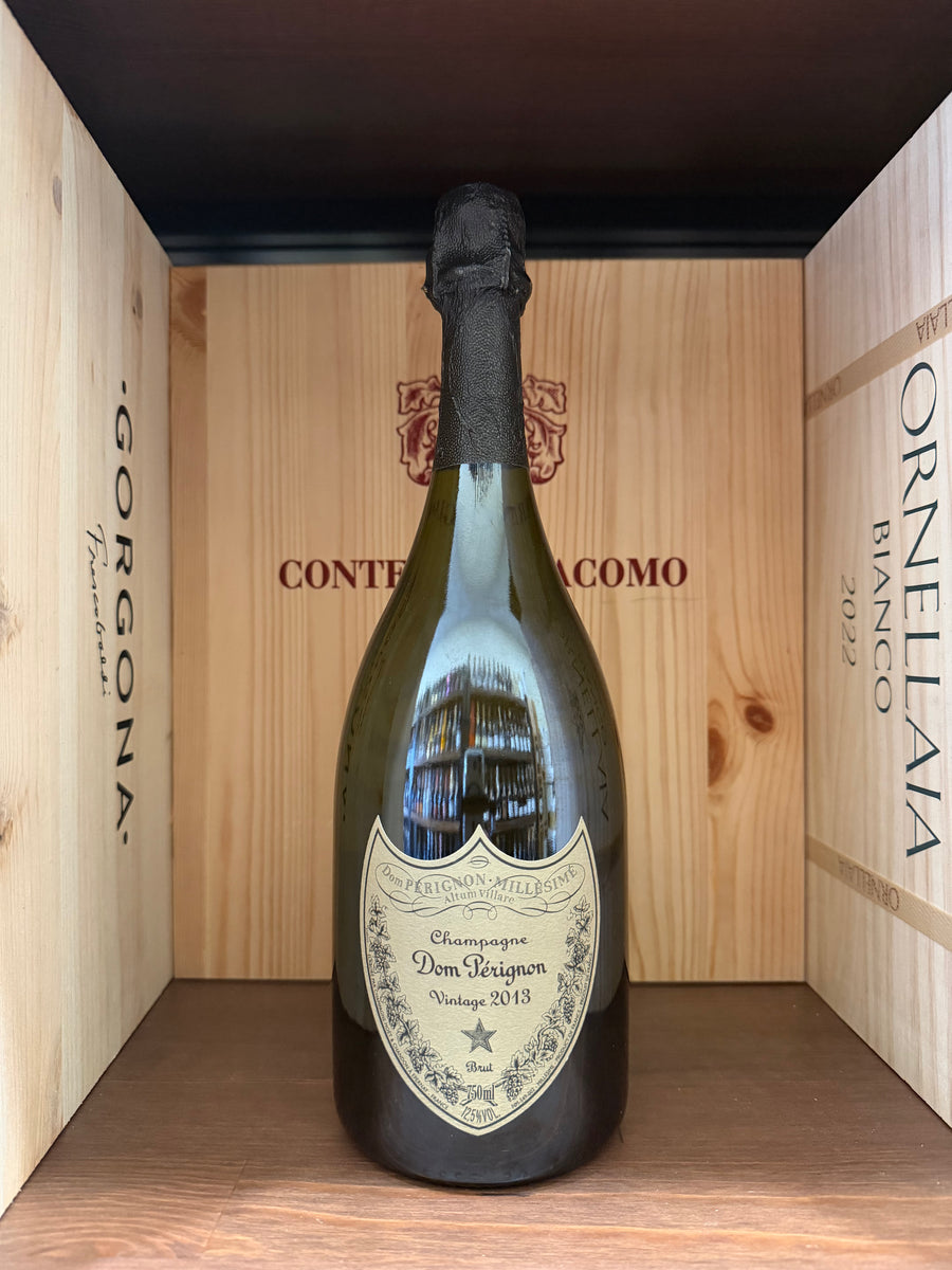 Bottiglia di Dom Pérignon Vintage 2013 di prestigiosa enoteca, con etichetta elegante e dettagli della capsula in oro.