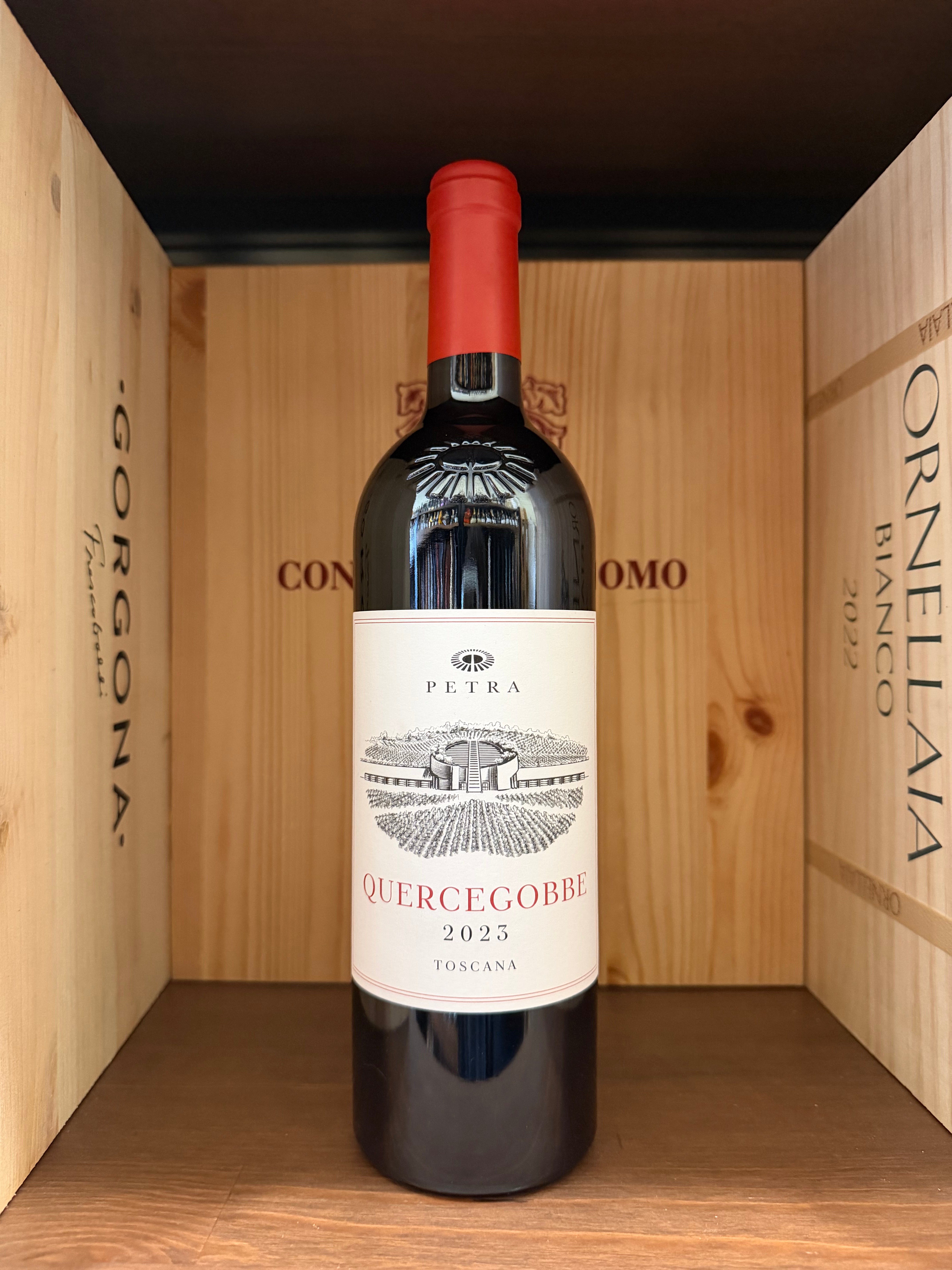 Vaschetta di vino Quercegobbe 2023 Petra di Enoteche Toscane, bottiglia di vino rosso con etichetta elegante.