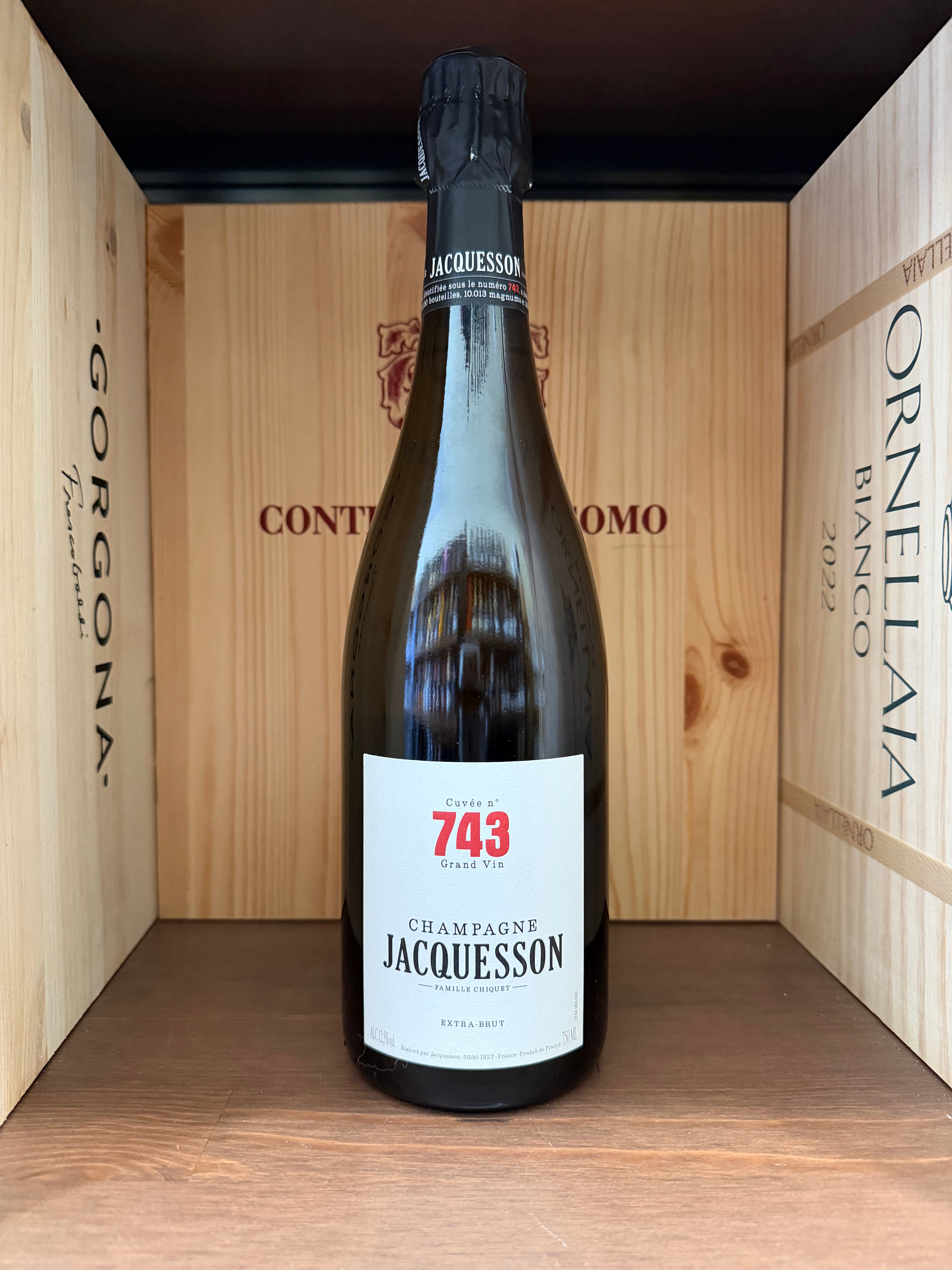 Bottiglia di Champagne Jacquesson Cuvée n.743 Extra Brut 2019 con etichetta elegante e dettagliata, in un calice trasparente.