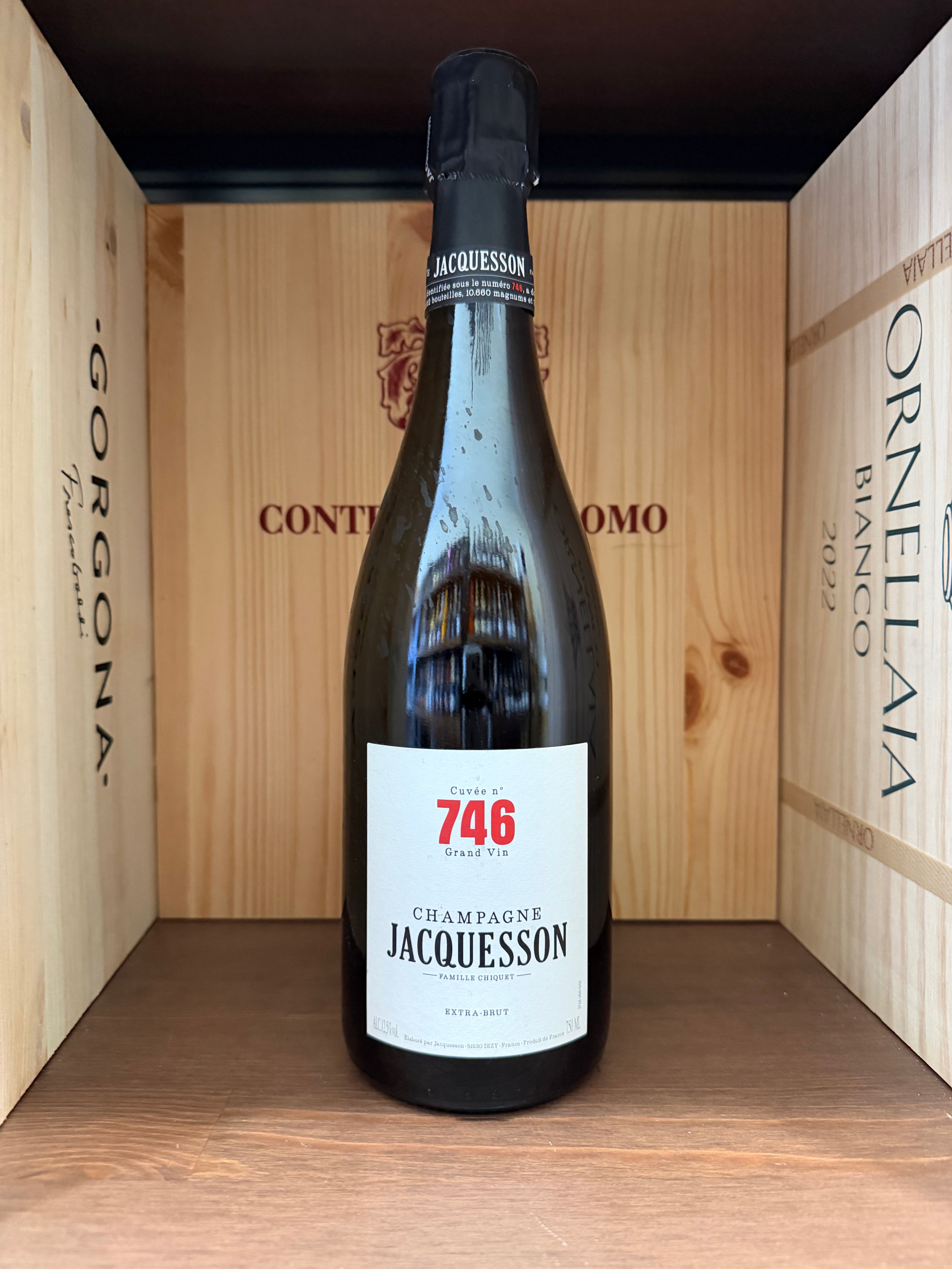 Vaso di vetro con champagne Jacquesson Cuvée n.746 Extra Brut 2023, bollicine dorate e bolle in evidenza in un bicchiere.