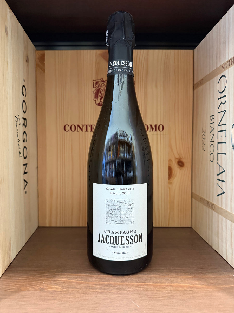 Calice di vino Jacquesson Avize-ChampCain 2013 Extra Brut, bottiglia di champagne di alta qualità su sfondo neutro.