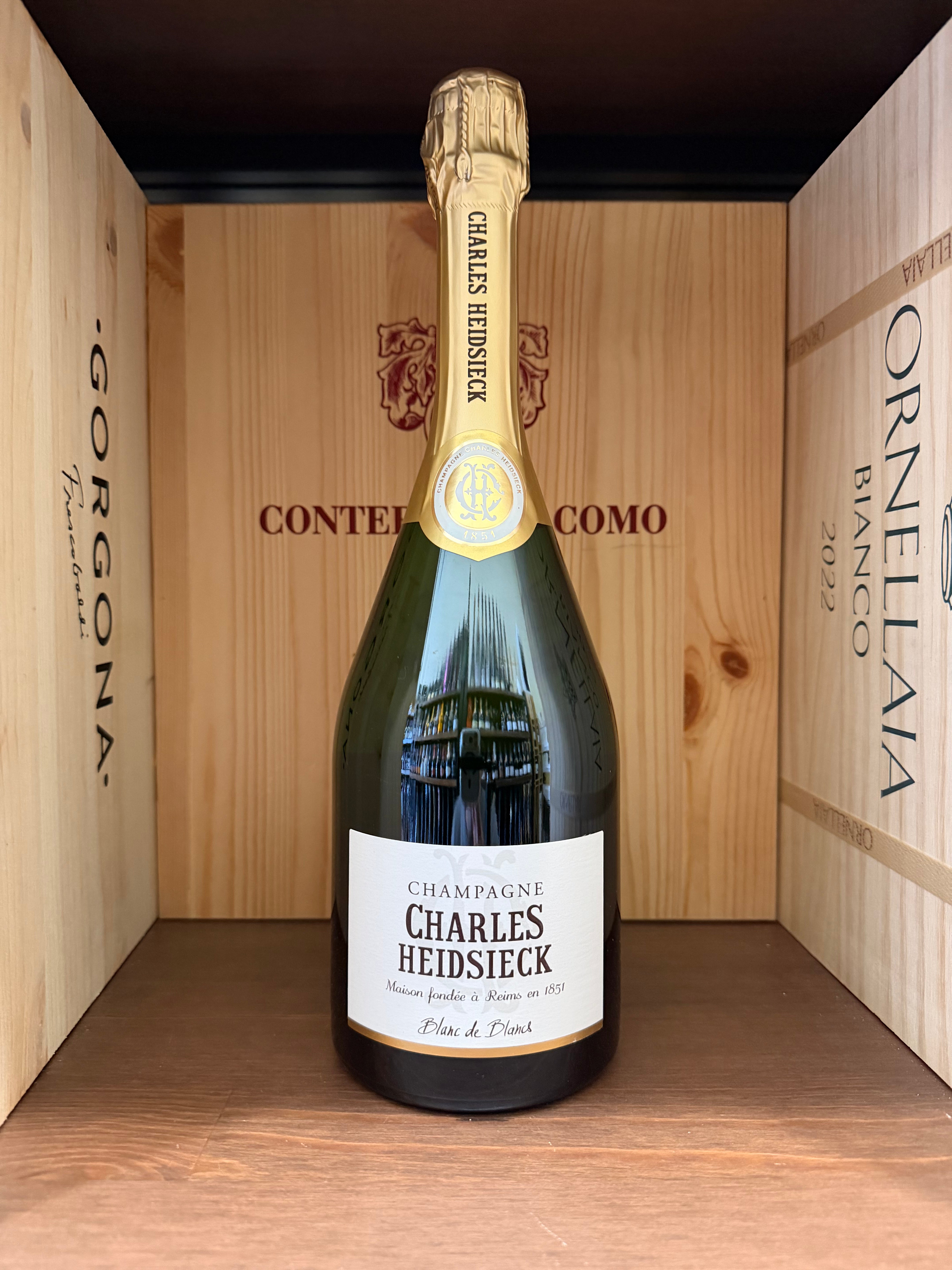 Flûte di champagne Charles Heidsieck Blanc de Blancs con bollicine dorate e bollicine fini, in un bicchiere elegante.
