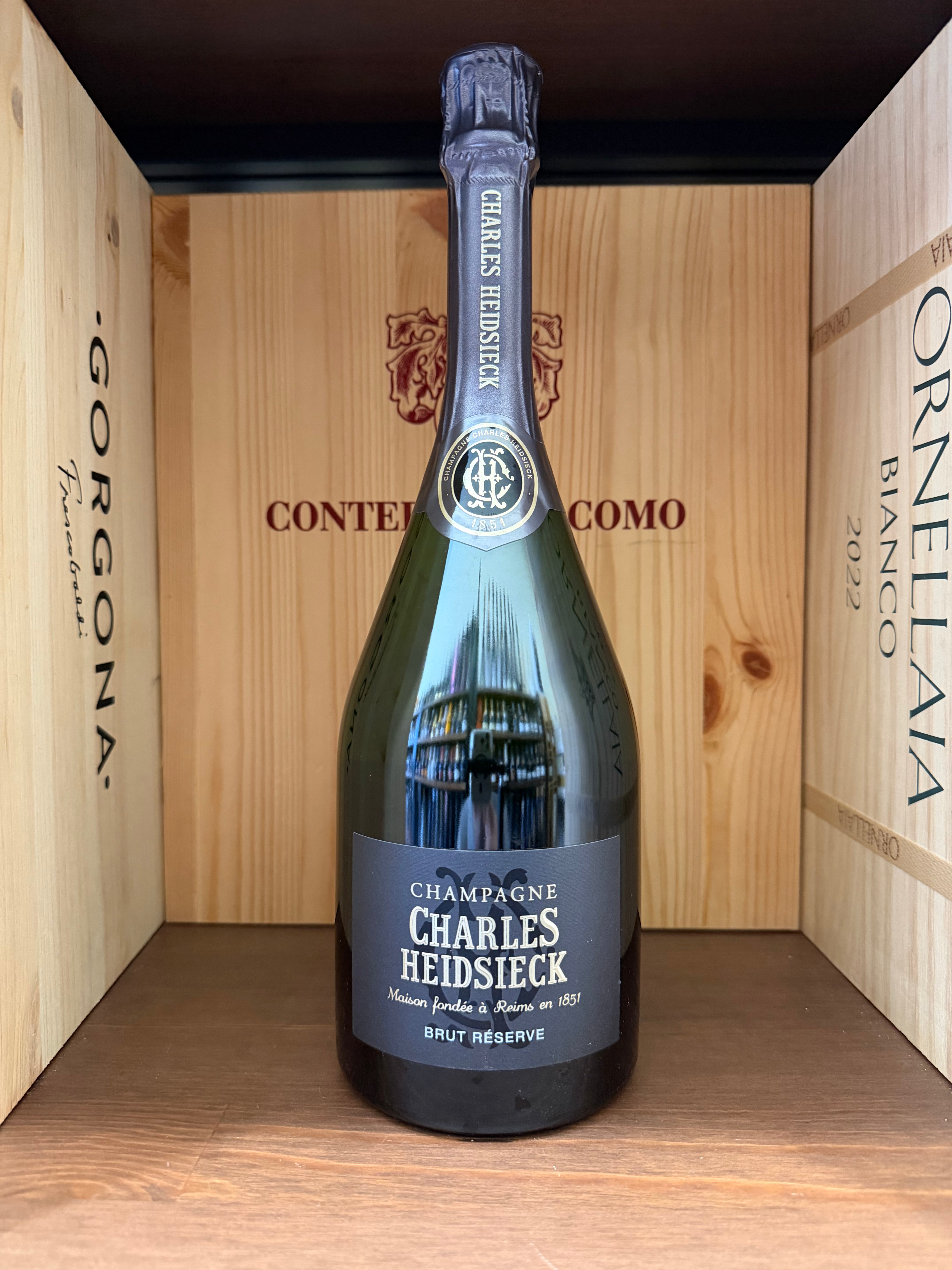 Flûte di champagne Charles Heidsieck Brut Réserve in un bicchiere, con etichetta visibile, su tavolo elegante.