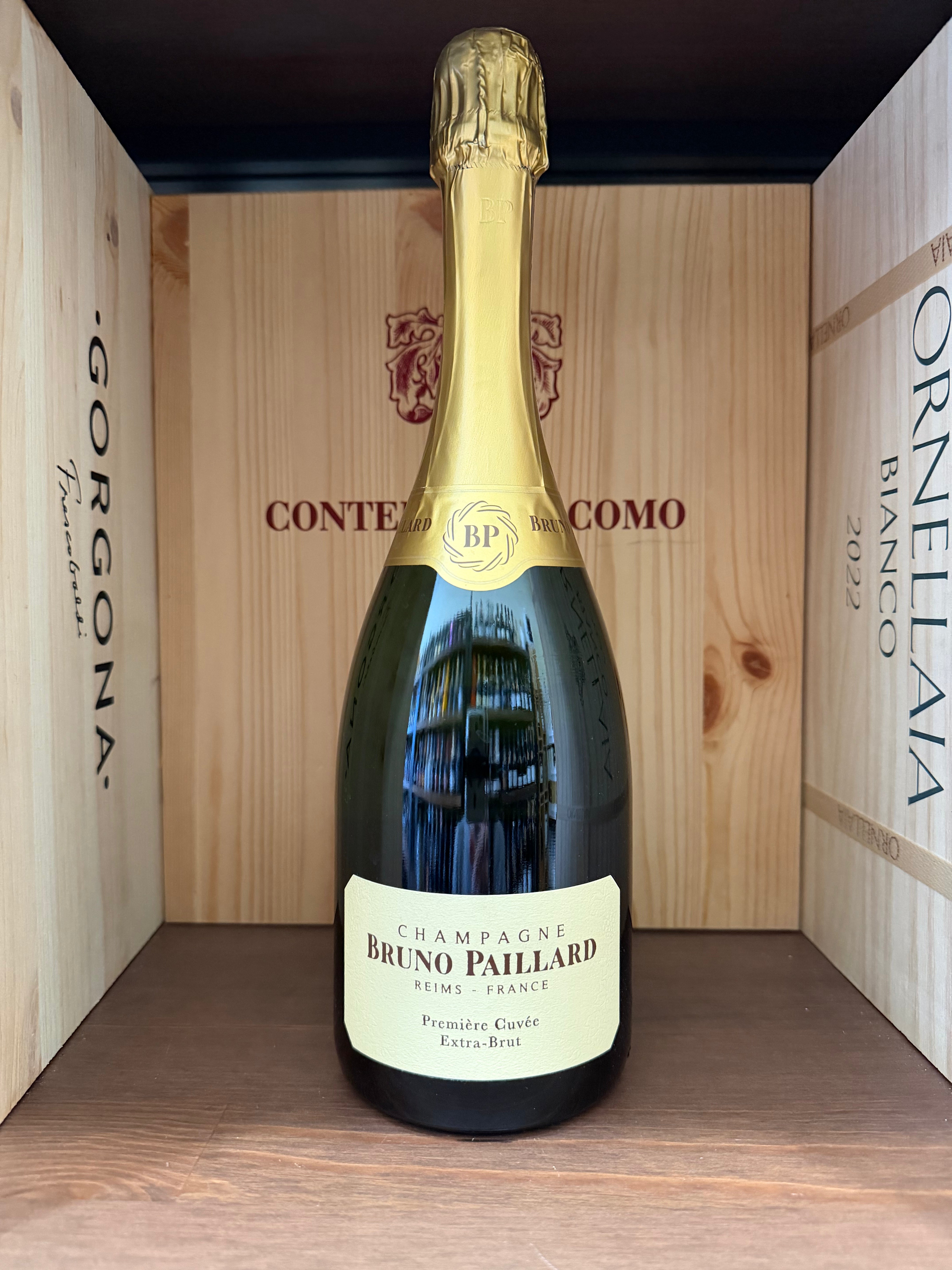 Bottiglia di champagne Bruno Paillard Premier Cuvée Extra Brut con etichetta elegante, posizionata su una superficie chiara.