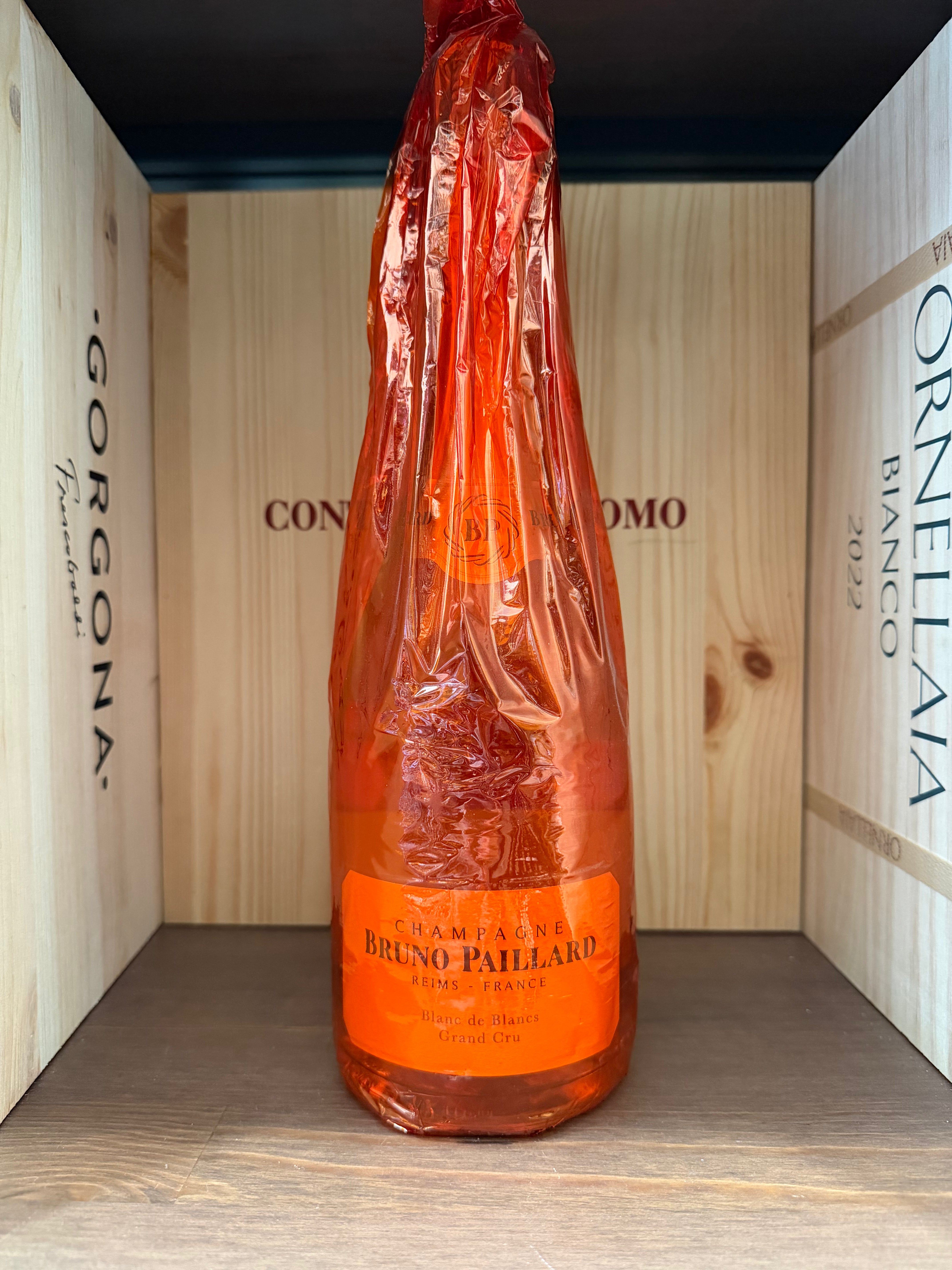 Bottiglia di Bruno Paillard Blanc de Blancs Gran Cru, vino spumante elegante con etichetta dettagliata, in un bicchiere da degustazione