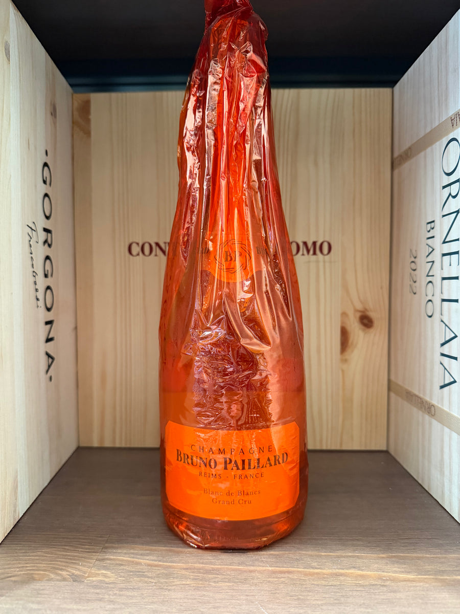 Bottiglia di Bruno Paillard Blanc de Blancs Gran Cru, vino spumante elegante con etichetta dettagliata, in un bicchiere da degustazione