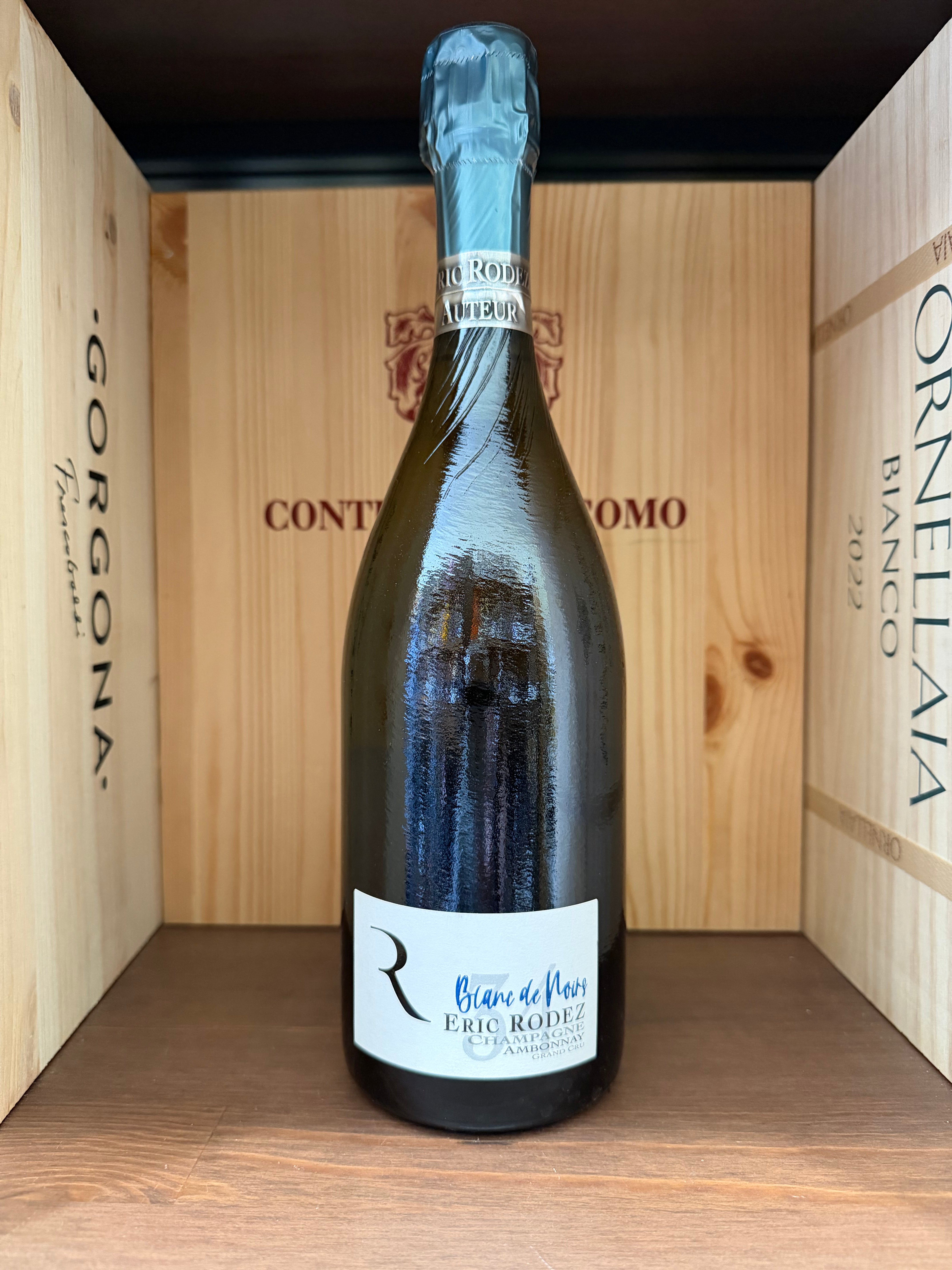 Vaso di vino rosso Eric Rodez Blanc de Noirs in bottiglia, con etichetta elegante e dettaglio della capsula in oro, su sfondo neutro.