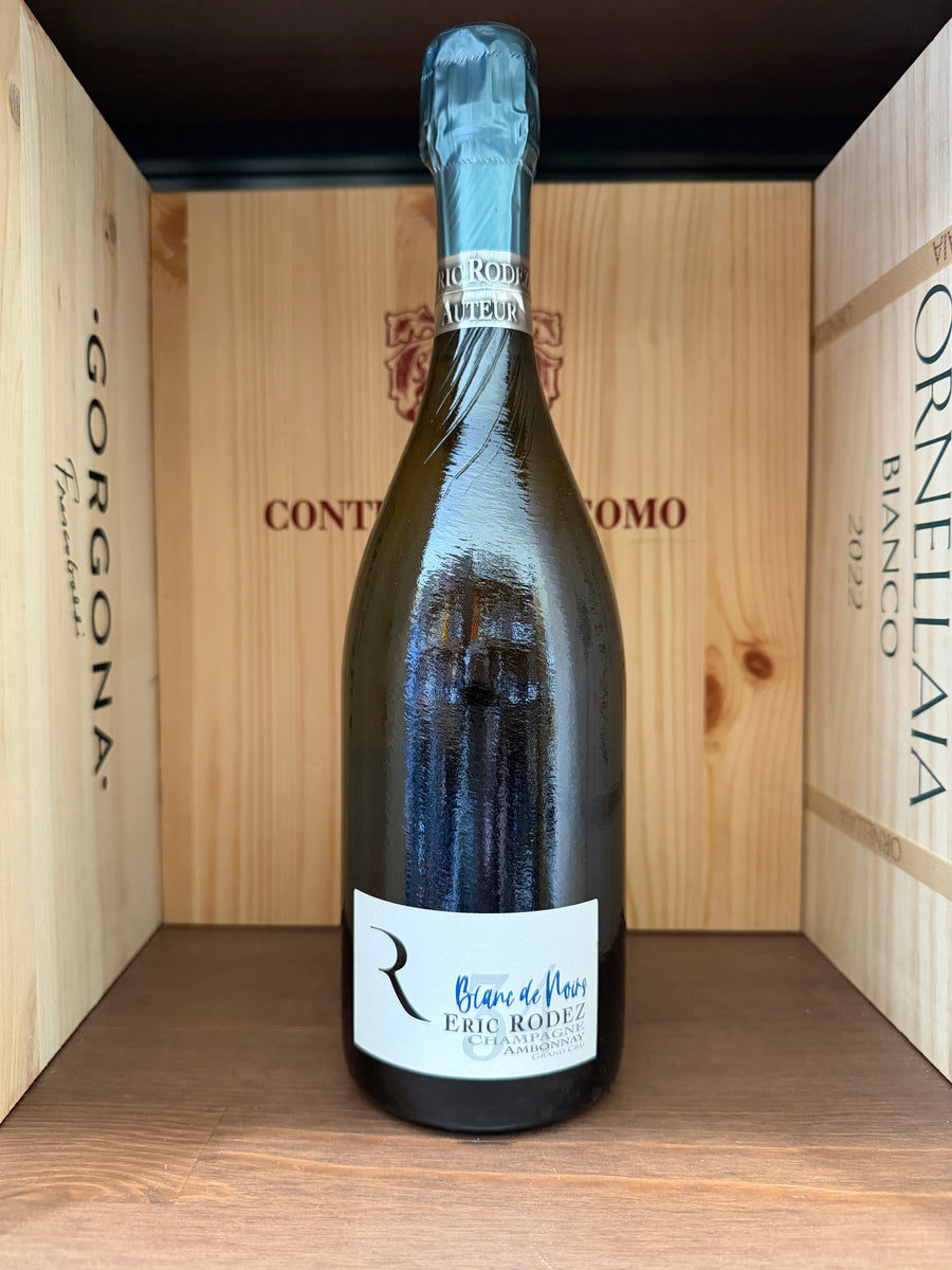 Vaso di vino rosso Eric Rodez Blanc de Noirs in bottiglia, con etichetta elegante e dettaglio della capsula in oro, su sfondo neutro.
