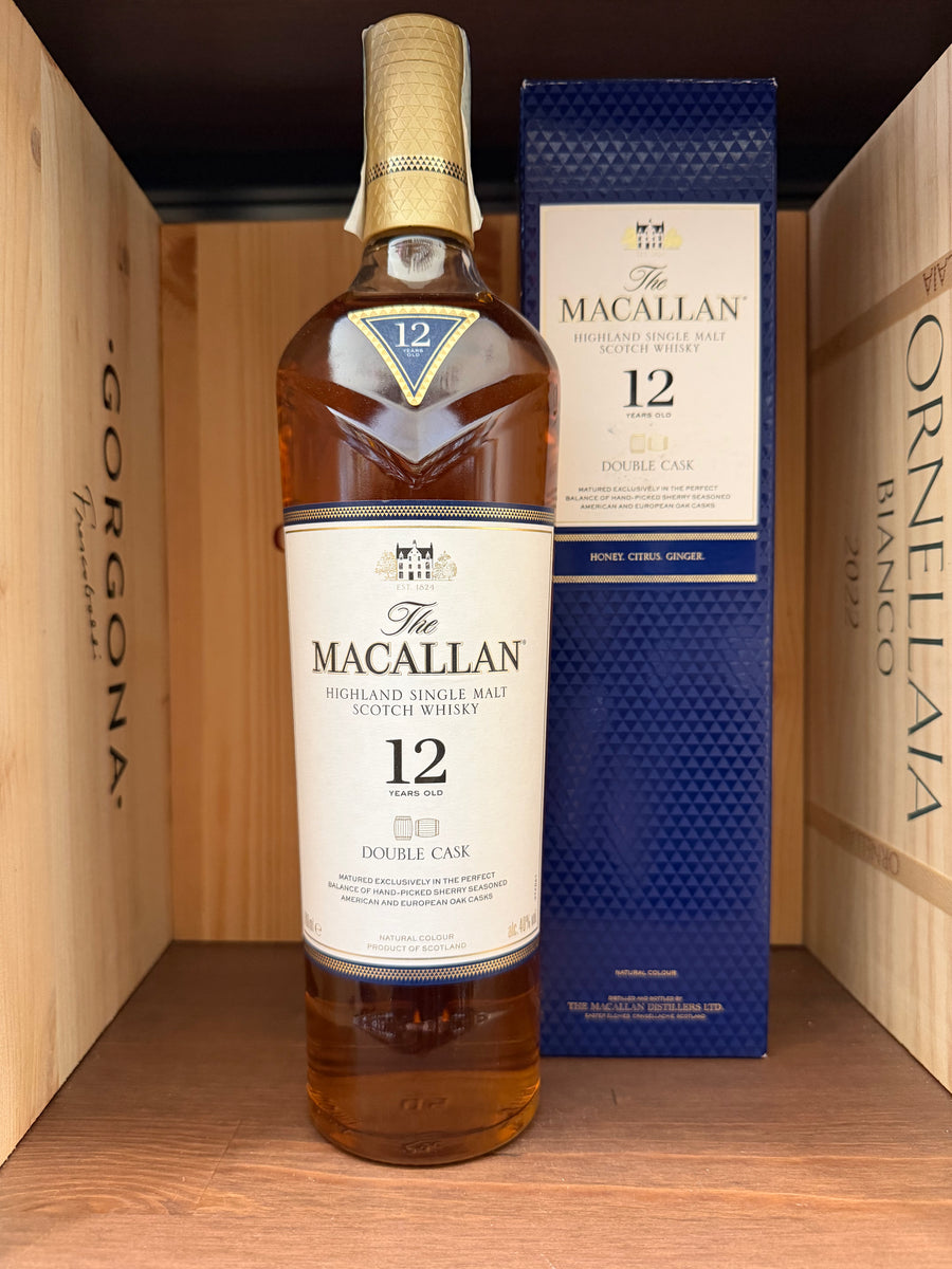 Bottiglia di whisky The Macallan 12 anni Double Cask con etichetta dettagliata, in un bicchiere di degustazione.