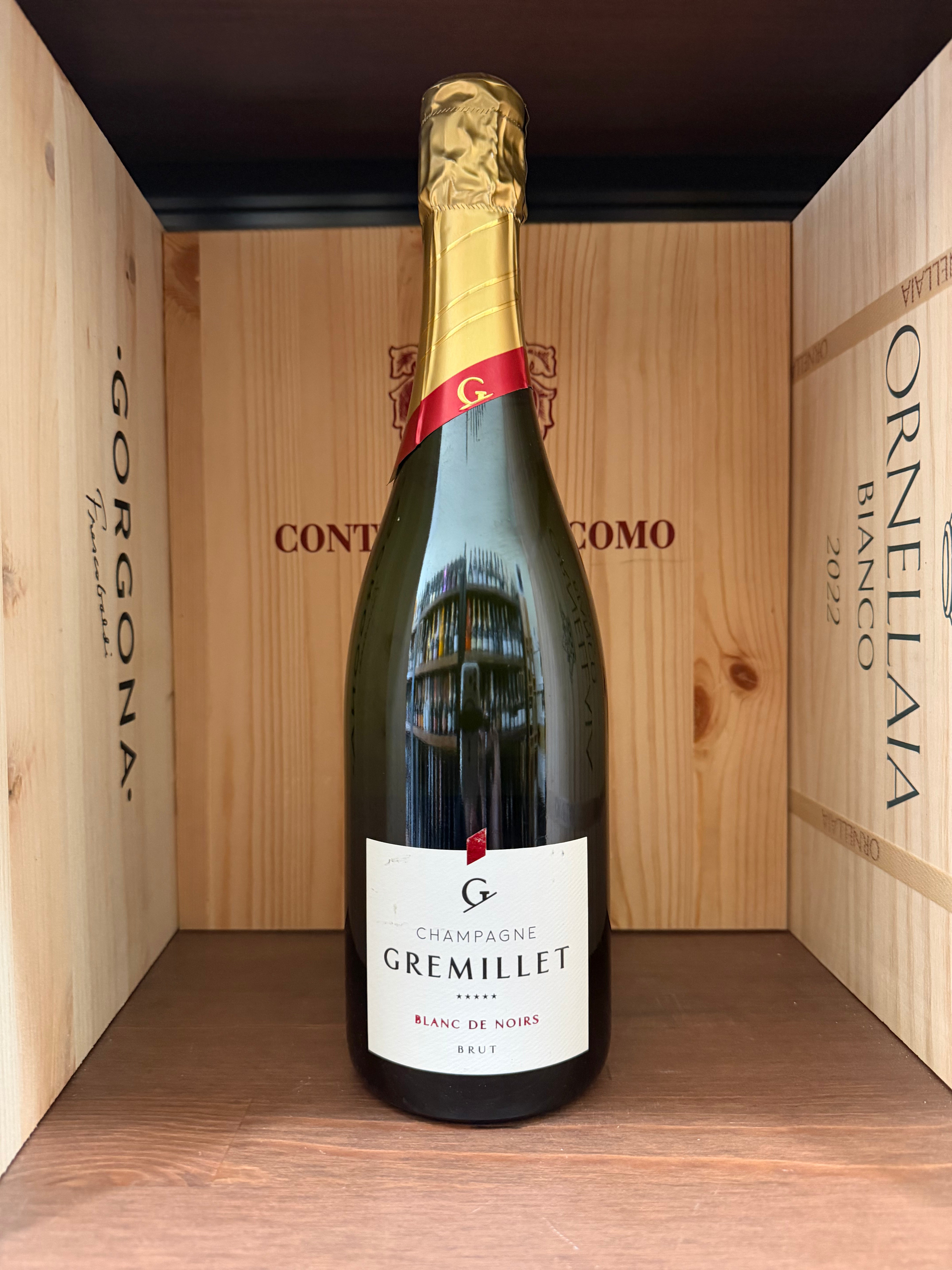 Calice di Champagne Gremillet Blanc De Noirs Brut, vino spumante italiano in bottiglia con etichetta elegante.