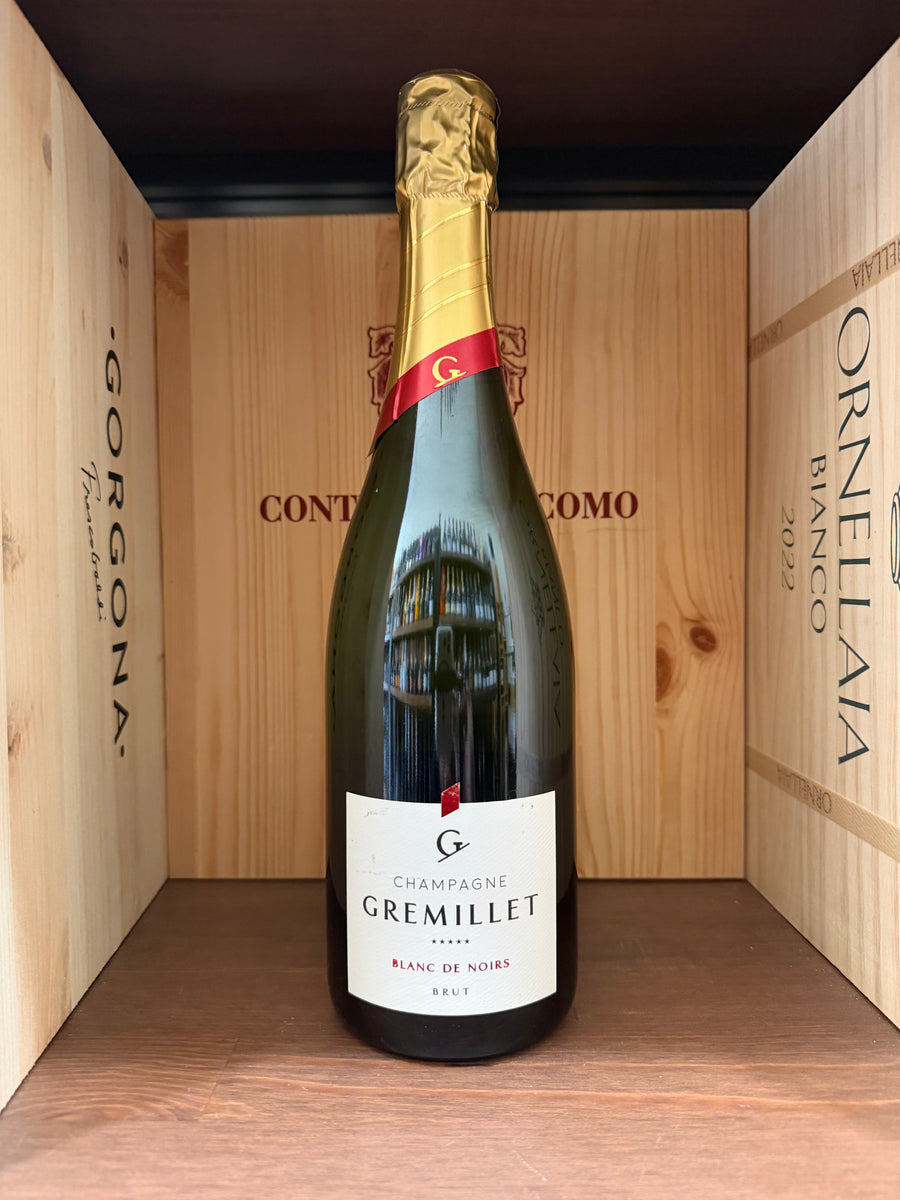 Calice di Champagne Gremillet Blanc De Noirs Brut, vino spumante italiano in bottiglia con etichetta elegante.