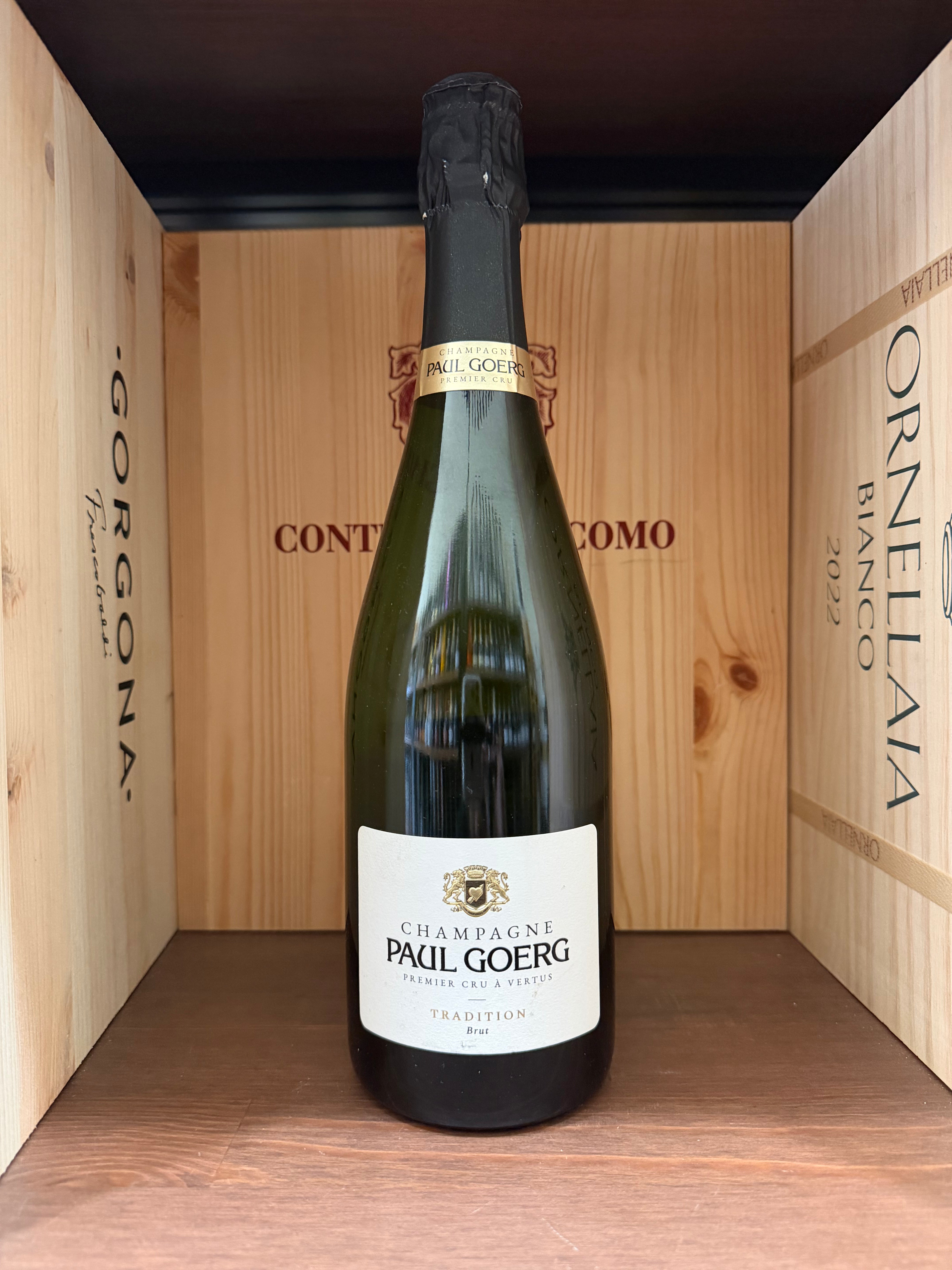 Flûte di champagne Paul Goerg Premier Cru Tradition Brut con bollicine dorate e bollicine fini, su sfondo elegante.