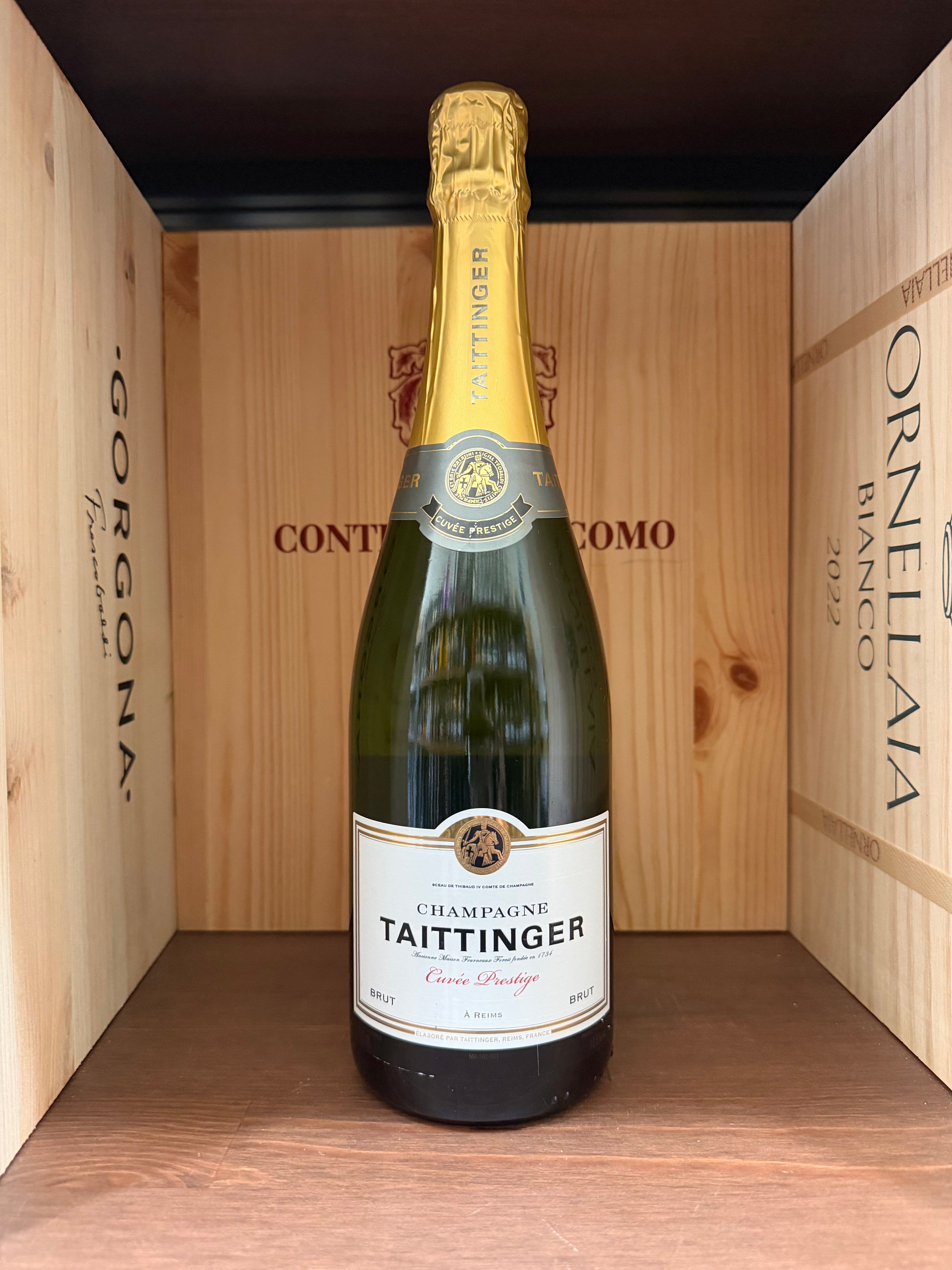 Flacone di champagne Taittinger Cuvée Prestige Brut in bottiglia elegante, vista laterale su etichetta e dettagli della capsula.
