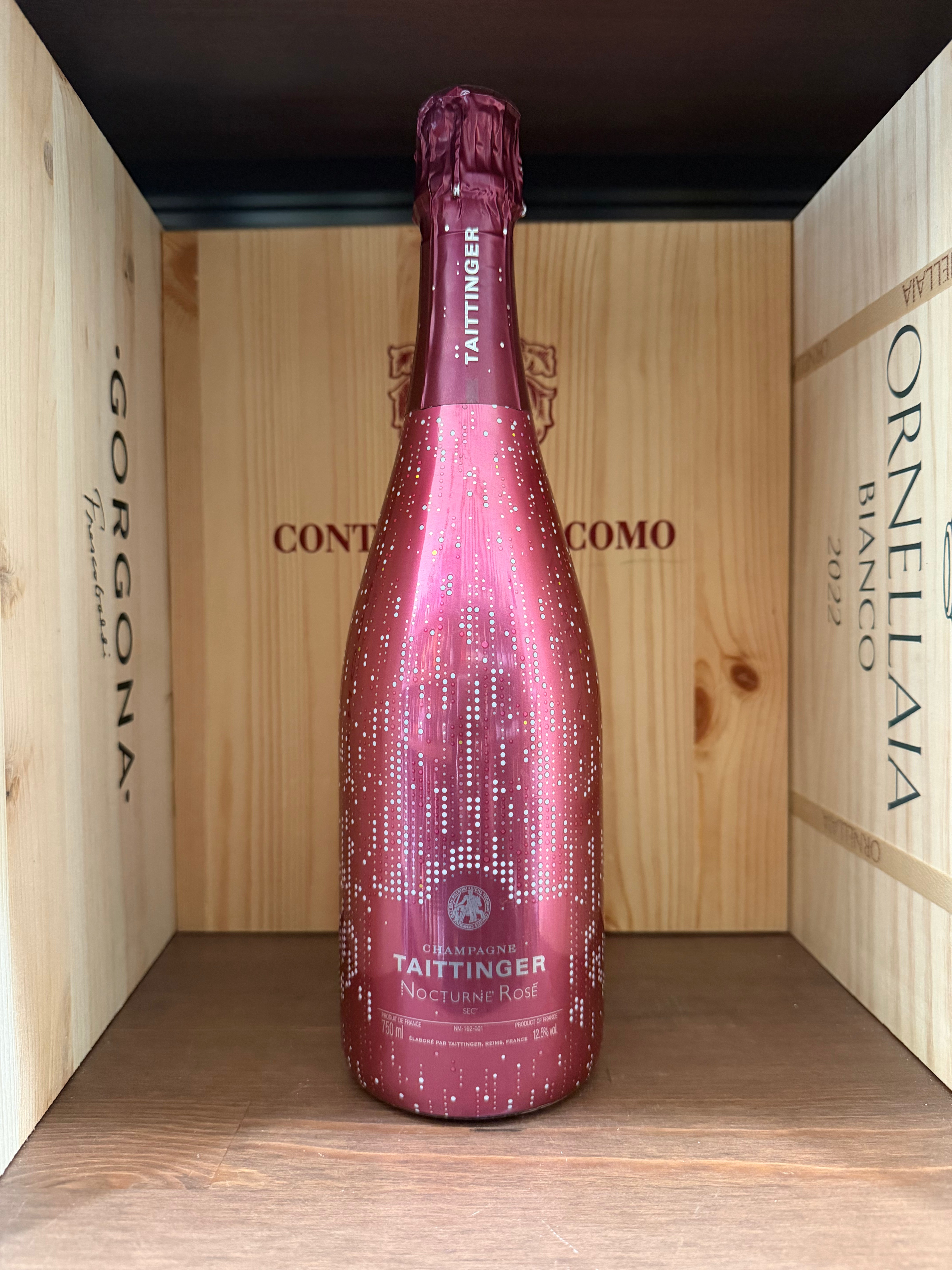 Bottiglia di Taittinger Nocturne Rosé Cuvée, champagne rosato di alta qualità, con etichetta elegante e dettagli raffinati.