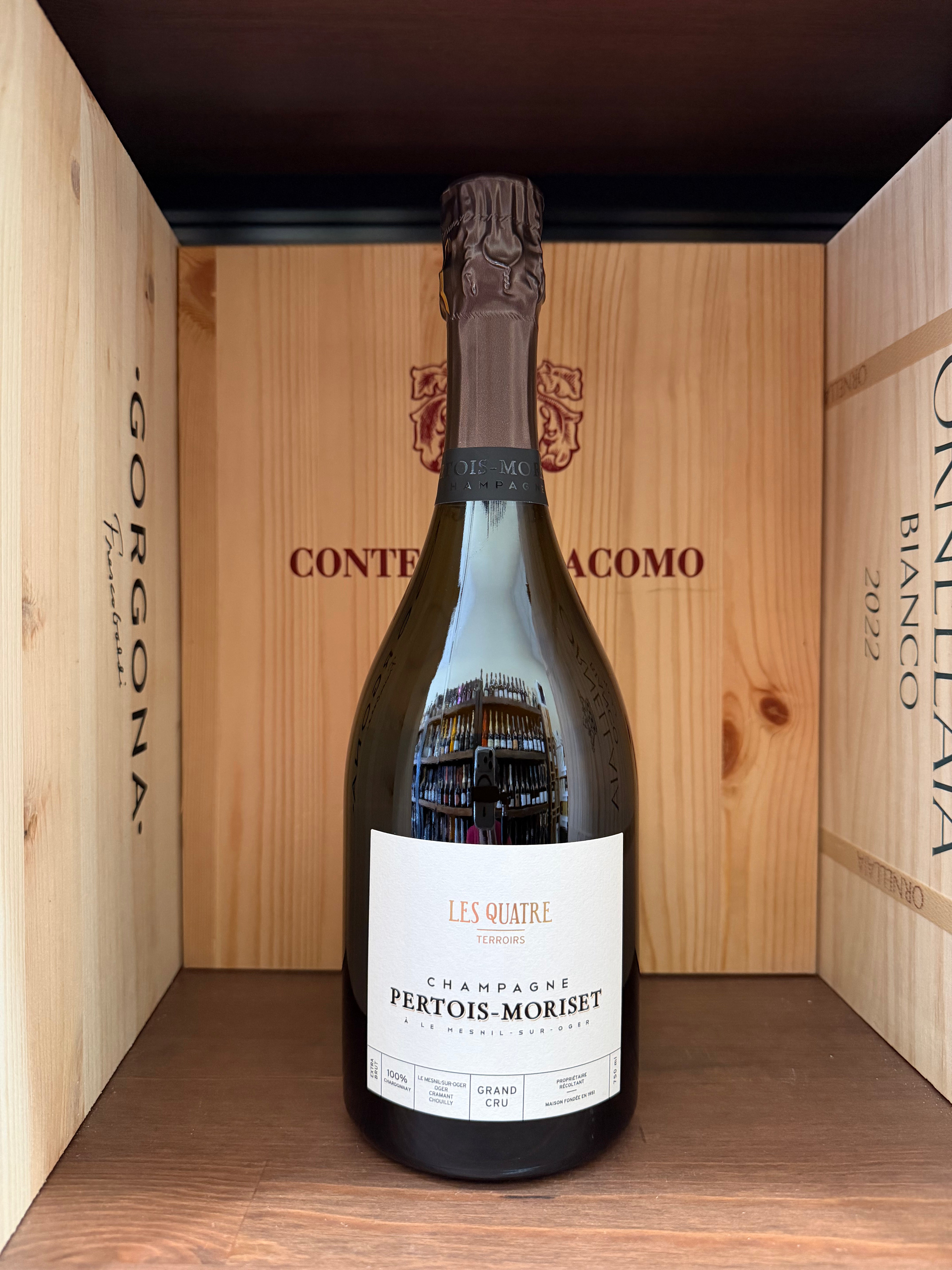Vetro di vino Pertois-Moriset Les Quatre Gran Cru, bottiglia elegante con etichetta dettagliata, su sfondo neutro.